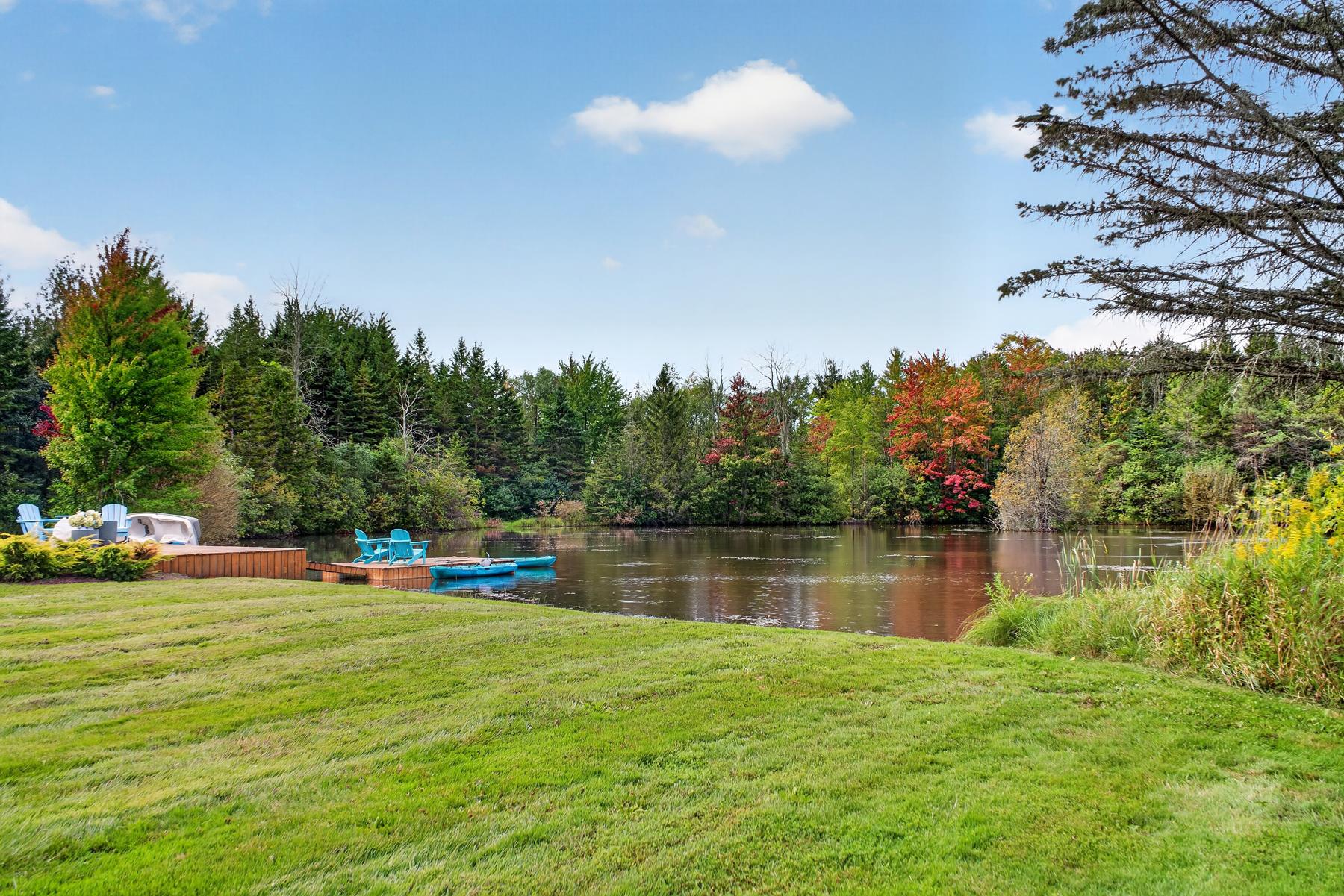 The pond's edge with the dock and autumn colour beyond