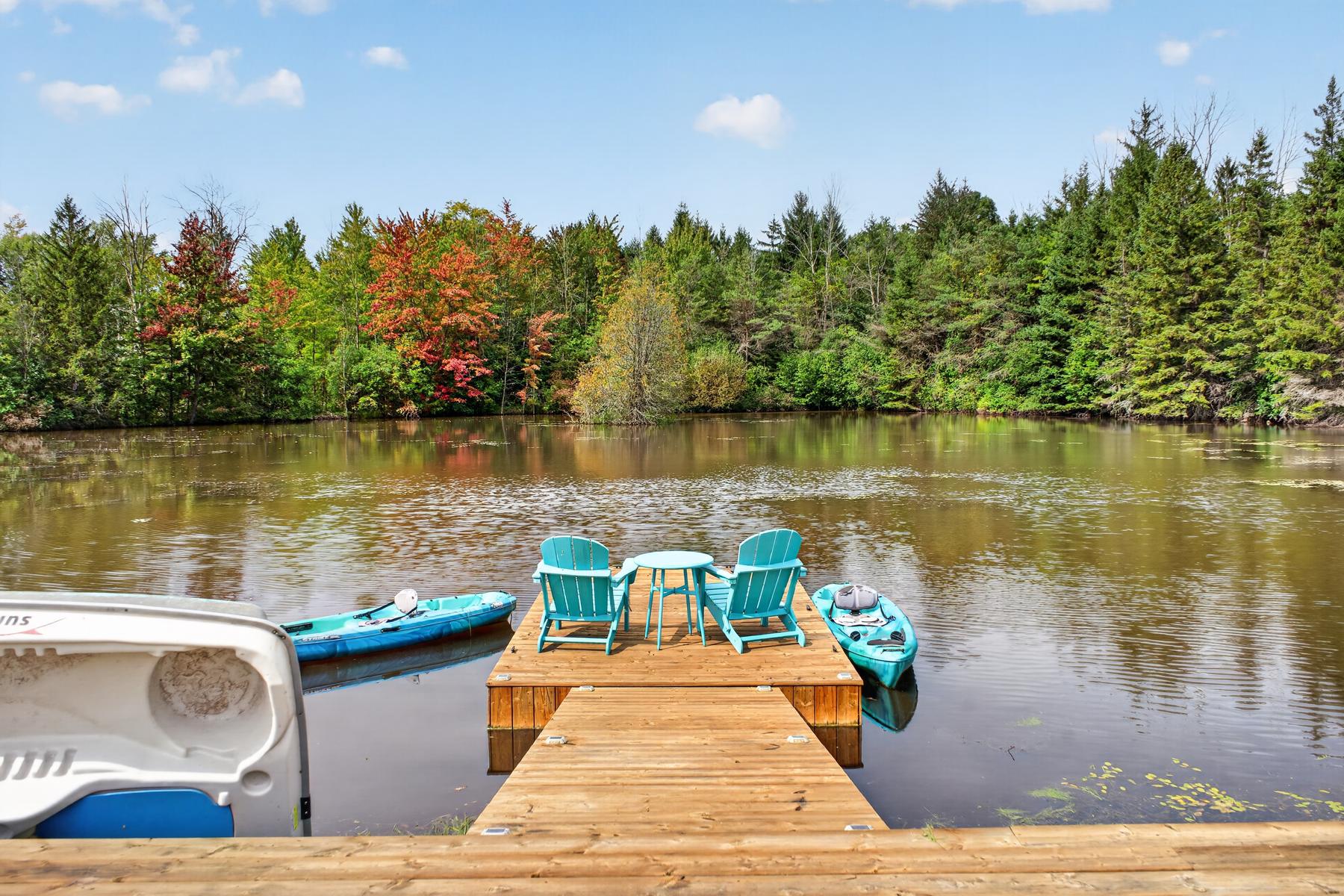 Adirondack chairs, kayaks and a pedal boat on the dock